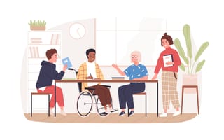 Four people of varying identities surround a conference table to represent workplace diversity and inclusion.