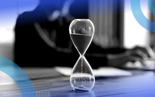 hour glass on desk with employee working in background