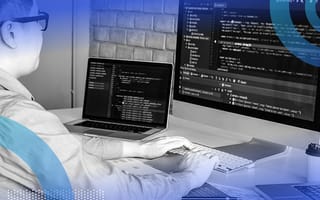 engineer writing code on two screens