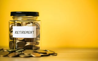 A jar labeled labeled "retirement" is filled with coins to represent retirement planning.