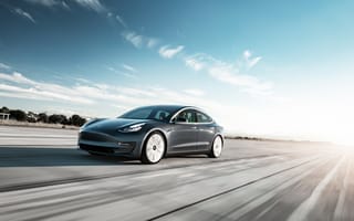 a car is pictured speeding down a road.