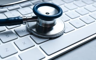 stethoscope resting atop mac keyboard