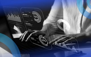 A person typing at a computer with a holographic dashboard wireframe.