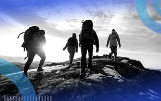 A group of four backpackers climbing a mountain or hill.