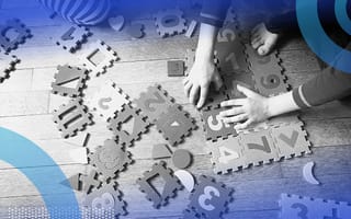 Children playing with foam number tiles on the floor.