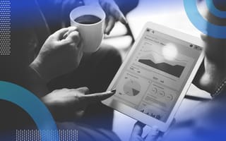 A tablet with various graphs is in the middle of a group of people. Only their hands are visible. Someone holds a cup of coffee.