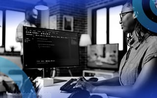A woman works on computer code on a monitor