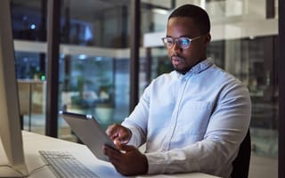A cybersecurity professional checking a tablet