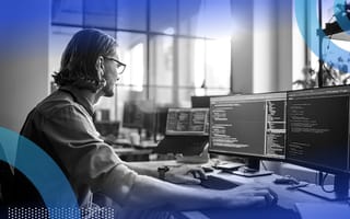 A software developer works on a desktop computer