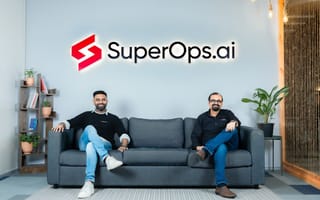 SuperOps co-founders pose together for a photo under the SuperOps logo sign.