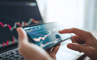 Woman is checking Bitcoin price chart on digital exchange on smartphone, cryptocurrency future price action prediction.