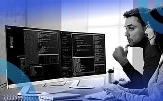 How to Conduct Better Coding Interviews Two computer engineers work on a terminal showing computer code