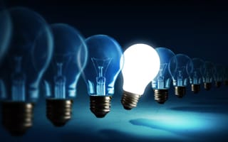 illuminated lightbulb sticking out form row of unlit lightbulbs