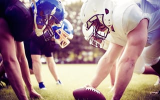 American football players prepare to start a game.
