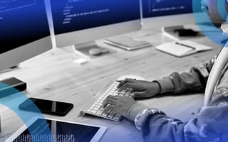 software developer writing python code on multiple monitor computer