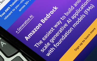 A closeup photo of a smartphone resting on a computer keyboard, and on the smartphone screen it reads the Amazon Bedrock homepage
