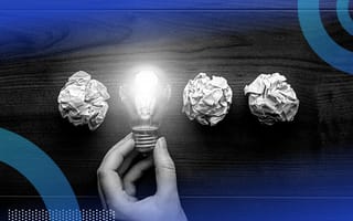 Three pieces of crumpled up paper and a hand holding a lit up lightbulb in a row.