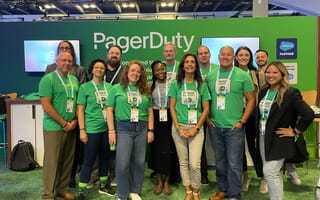 PagerDuty team members in green shirts in front of PagerDuty booth at a conference