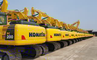 a line-up of yellow Komatsu excavators