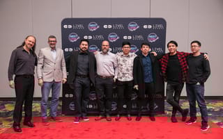 Eight members of the Level Access team standing on a red carpet in front of a branded step-and-repeat backdrop.