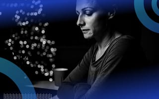A sad person with a background of holiday lights.