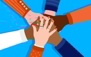 Diverse set of individuals stacking their hands on top of each other in a circle