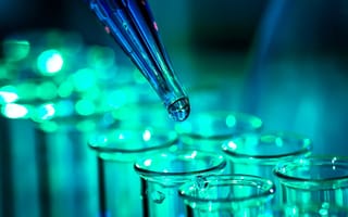 A close up of a pipette dropping liquid into a test tube.