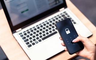 12 Cybersecurity Companies in London to Know A close up of a hand inputting a code into a smartphone lock screen.