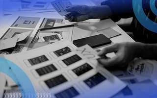 A UX designer works on prototypes with post it notes and schematics