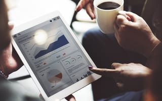 A close up of a tablet displaying charts and graphs of marketing metrics.
