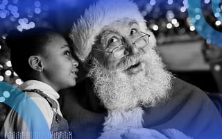 A little girl whispering in Santa’s ear.