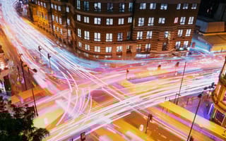 London vehicle traffic is photographed with a long exposure, creating colorful streaks of light.