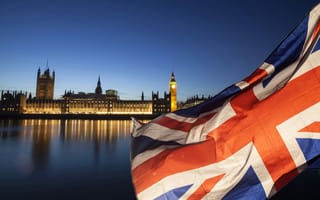 Photograph of the Big Ben building in London with a Union Jack flag in the foreground