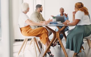 A group of marketing professionals sit around a conference table.