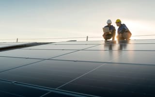 Two people analyze a solar grid.