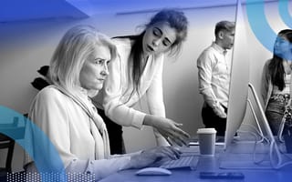 A younger woman criticizes an older woman who looks angry in front of a computer