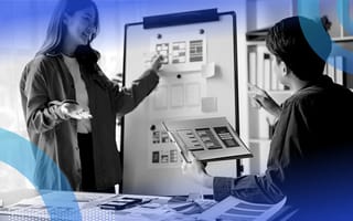 Two employees brainstorming design features on a white board