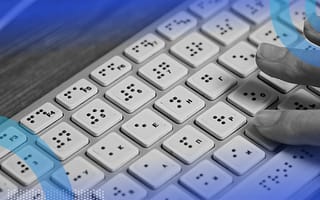 A hand typing on a braille computer keyboard.