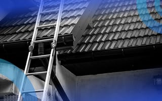 A metal ladder propped up against the tiled roof of a house.