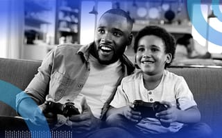A father and son smiling while playing video games together.