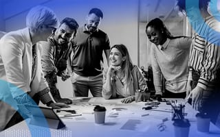 How to Get Ahead of 2024’s Biggest Challenges A diverse group of six coworkers around a table smiling while having a lively conversation.