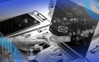 A close-up of a person’s hands typing on a laptop with a graphic of a notification bubble with a phone, email symble and @ symbol inside, with four email symbols floating away from the bubble becoming increasingly smaller.