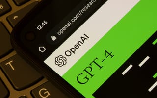 A close-up photograph of OpenAI's GPT-4 displayed on a smartphone, and the smartphone is laying on a laptop keyboard