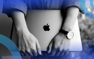 A woman wearing a watch holds a Macbook
