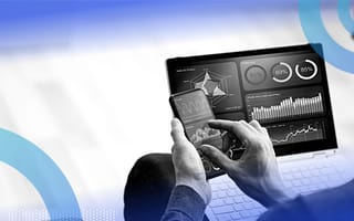 Marketer reviewing marketing data on laptop and phone