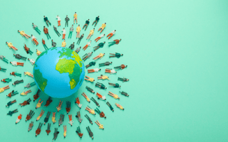 Clay figures surround an image of the globe