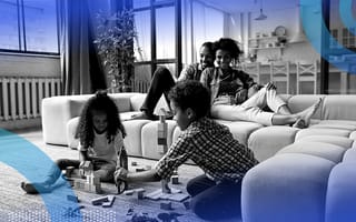 Black parents watching their children play with building blocks.