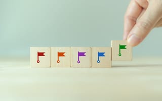 wooden blocks being placed in a row with colorful flags on each