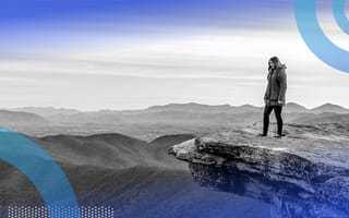 A person standing on a high rock outcropping.