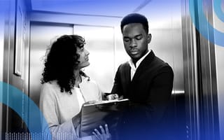 A woman holding a clipboard and smiling while pitching an idea to a man observing the clipboard in an elevator.